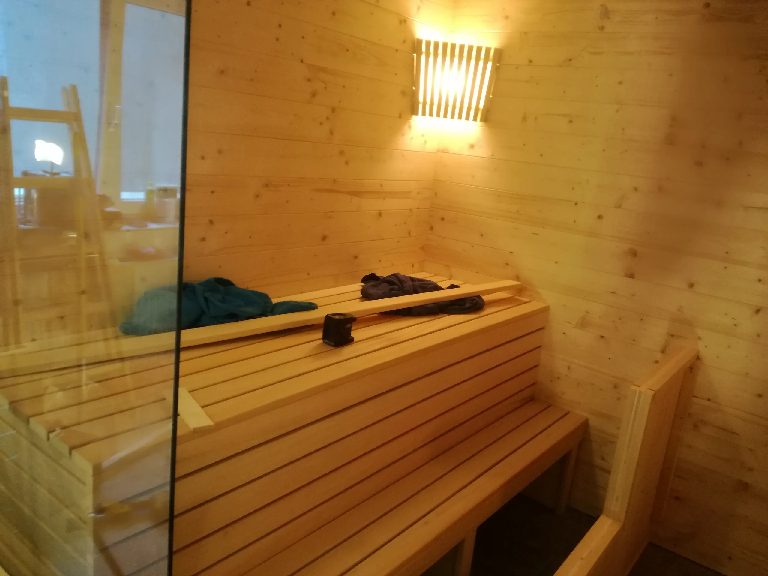Sauna mit Glasfront und warmer Beleuchtung