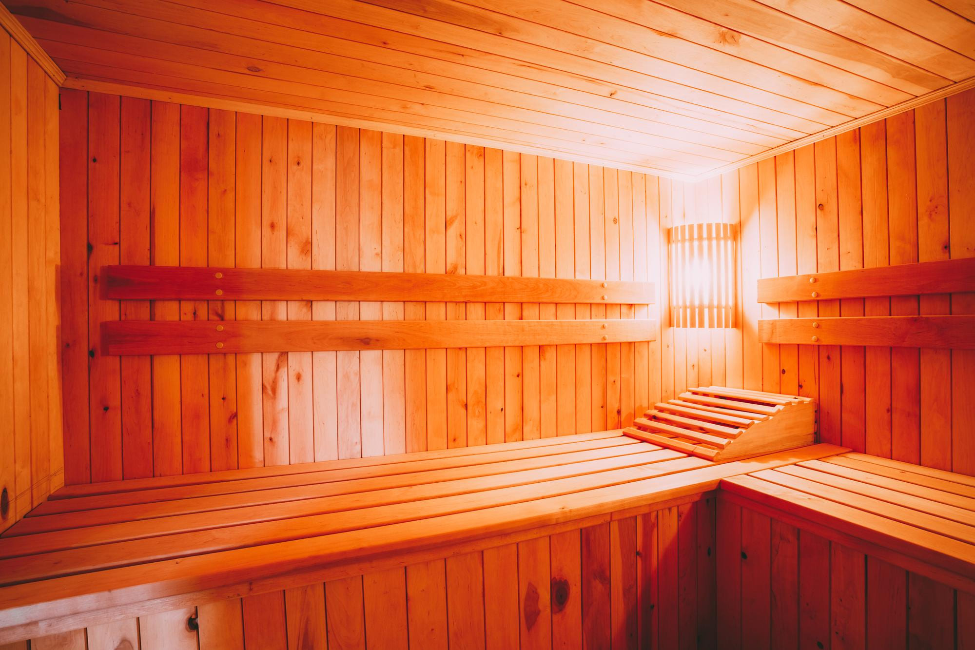 Finnische Sauna aus warmem Holz mit Bänken und Rückenlehnen