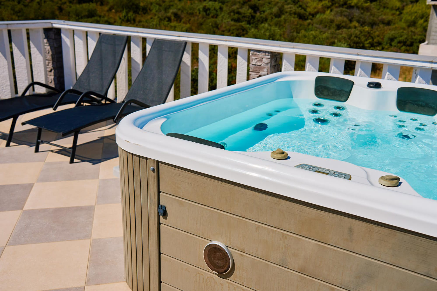 Whirlpool mit klarem Wasser und Liegen auf sonniger Terrasse